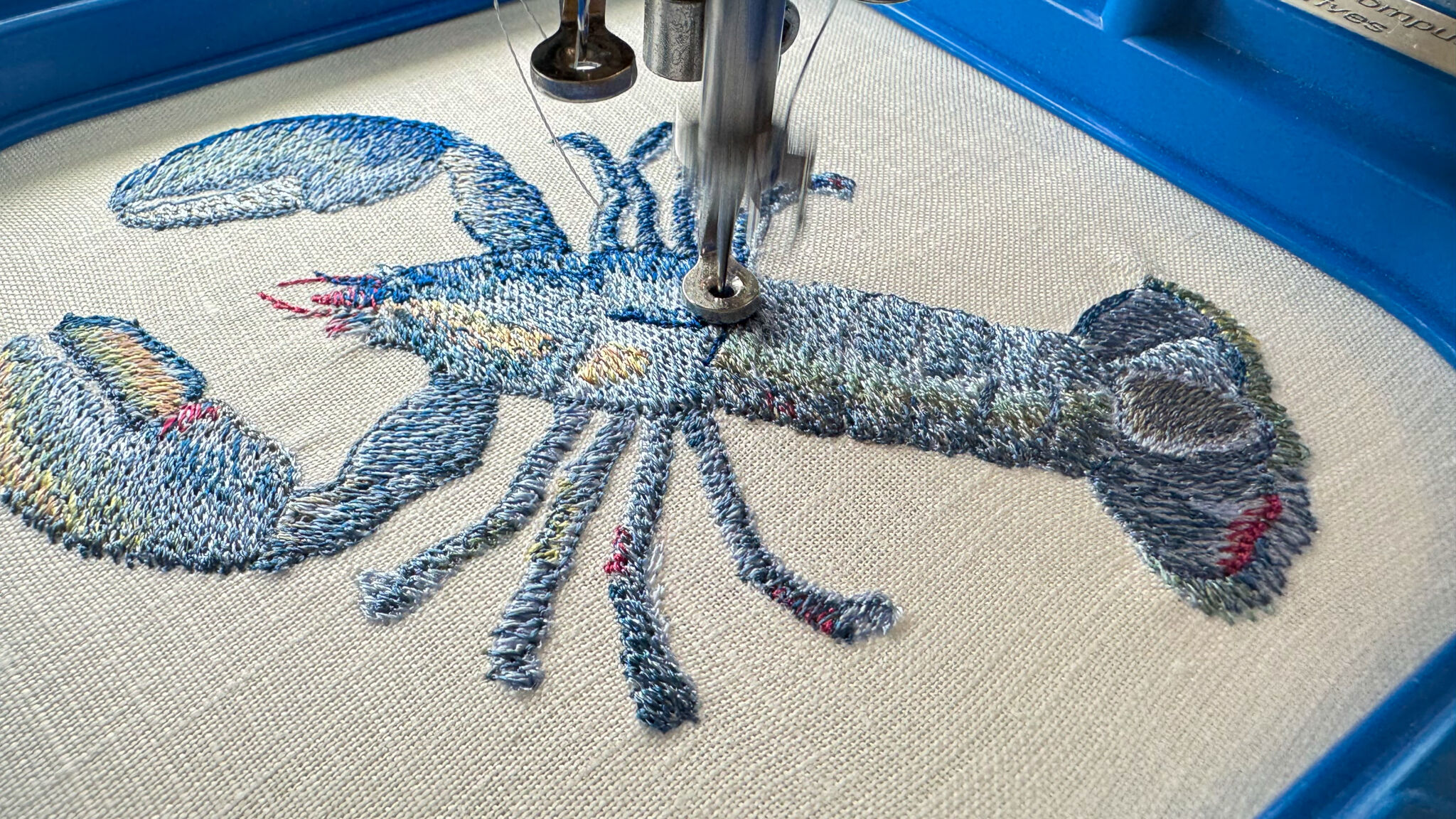 A lobster design being stitched on an embroidery machine
