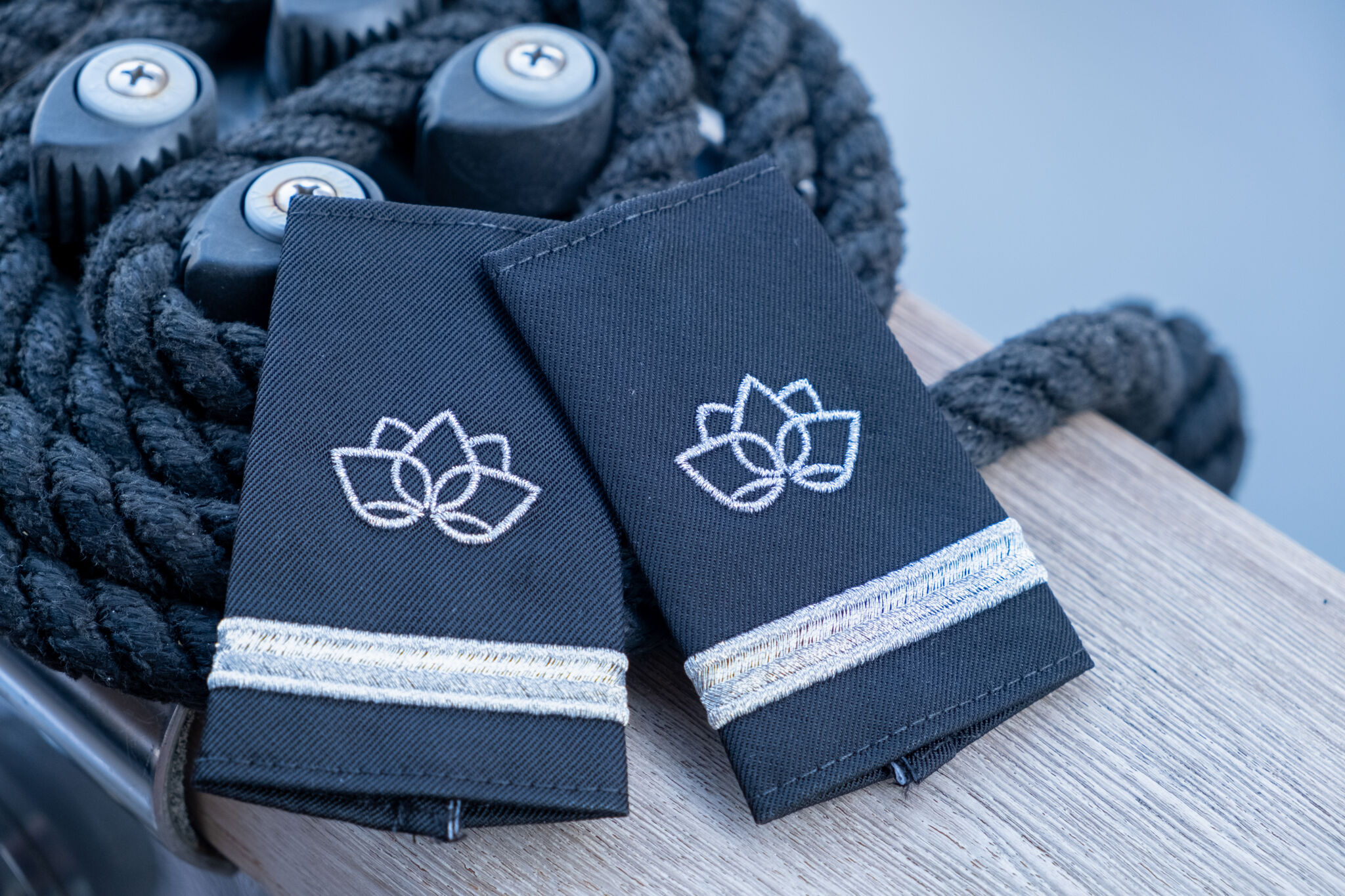 Embroidered navy epaulettes with a silver lotus design